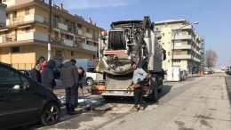 Operai al lavoro per liberare un tombino otturato